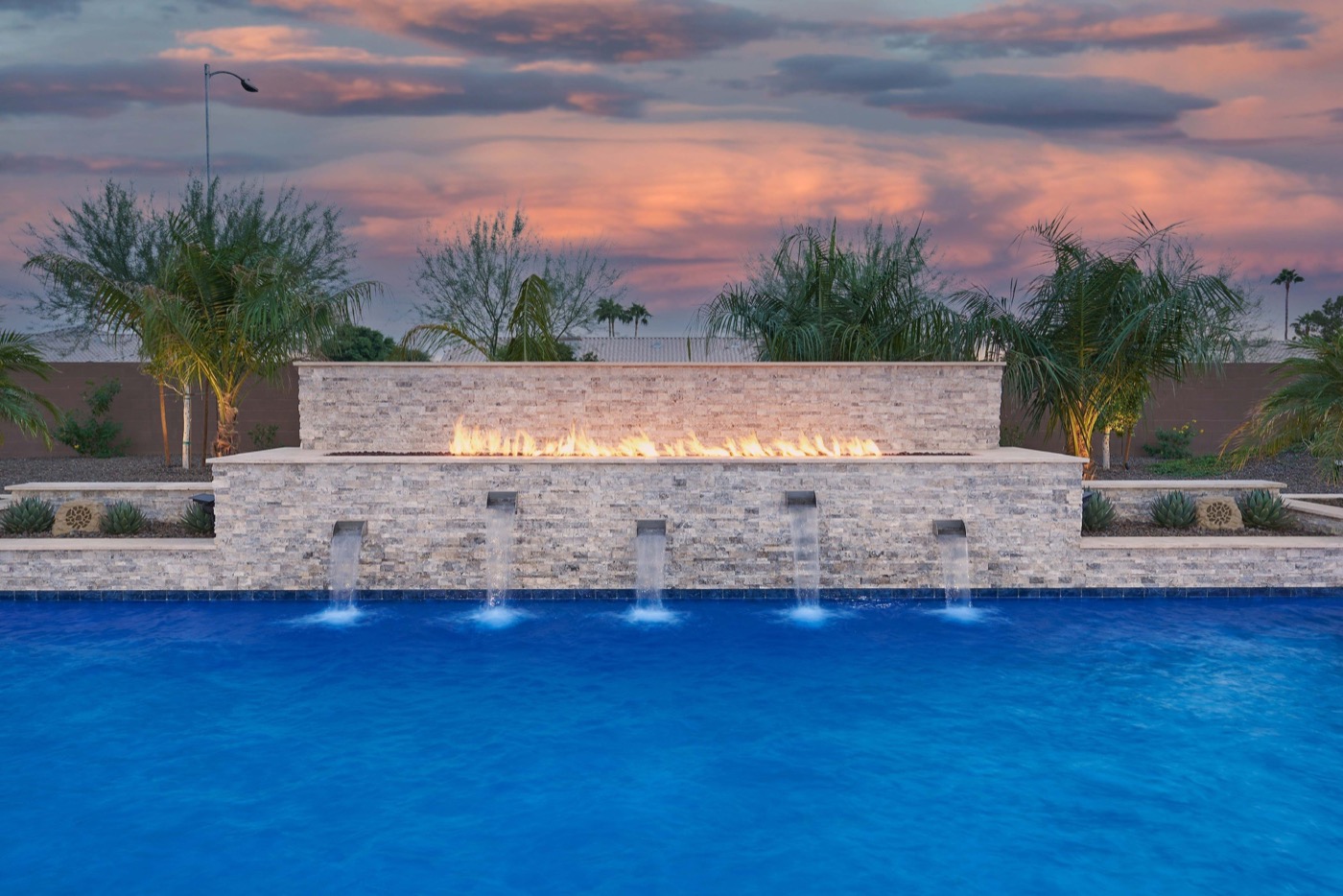Fire and water feature wall over custom pool at sunset — Phoenix Arizona
