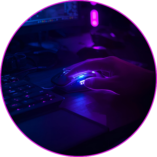 A person’s hand using a glowing RGB gaming mouse next to a keyboard in a dim, neon-lit computer setup.