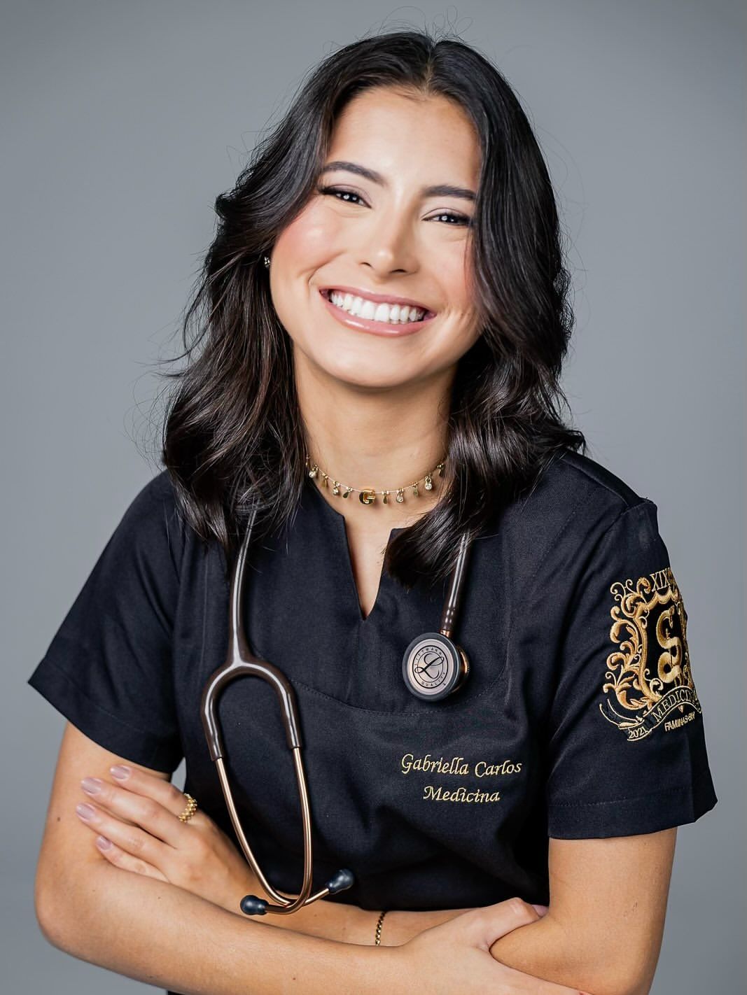 Smiling doctor in dark scrubs with a stethoscope