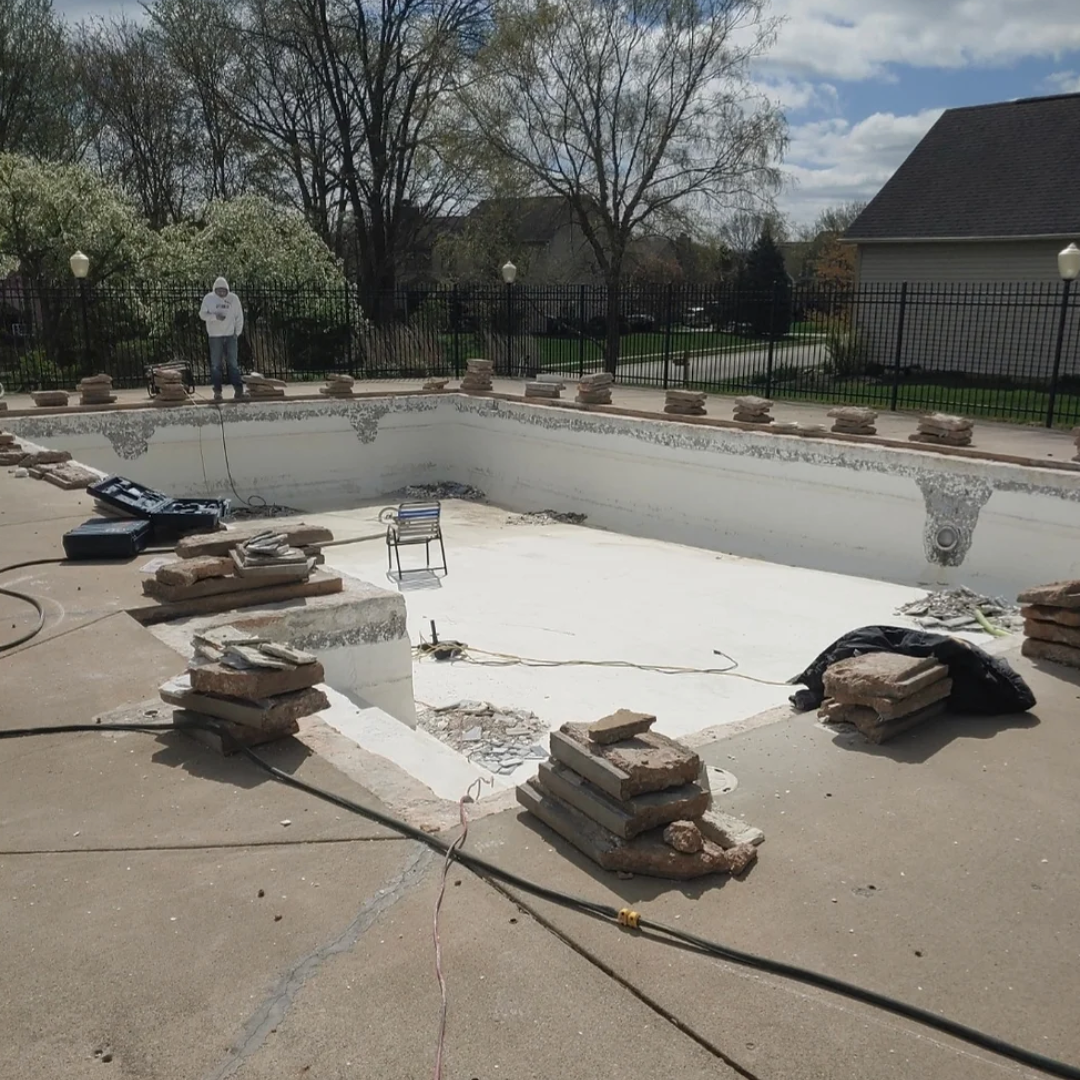 Swimming pool undergoing renovation in a residential backyard