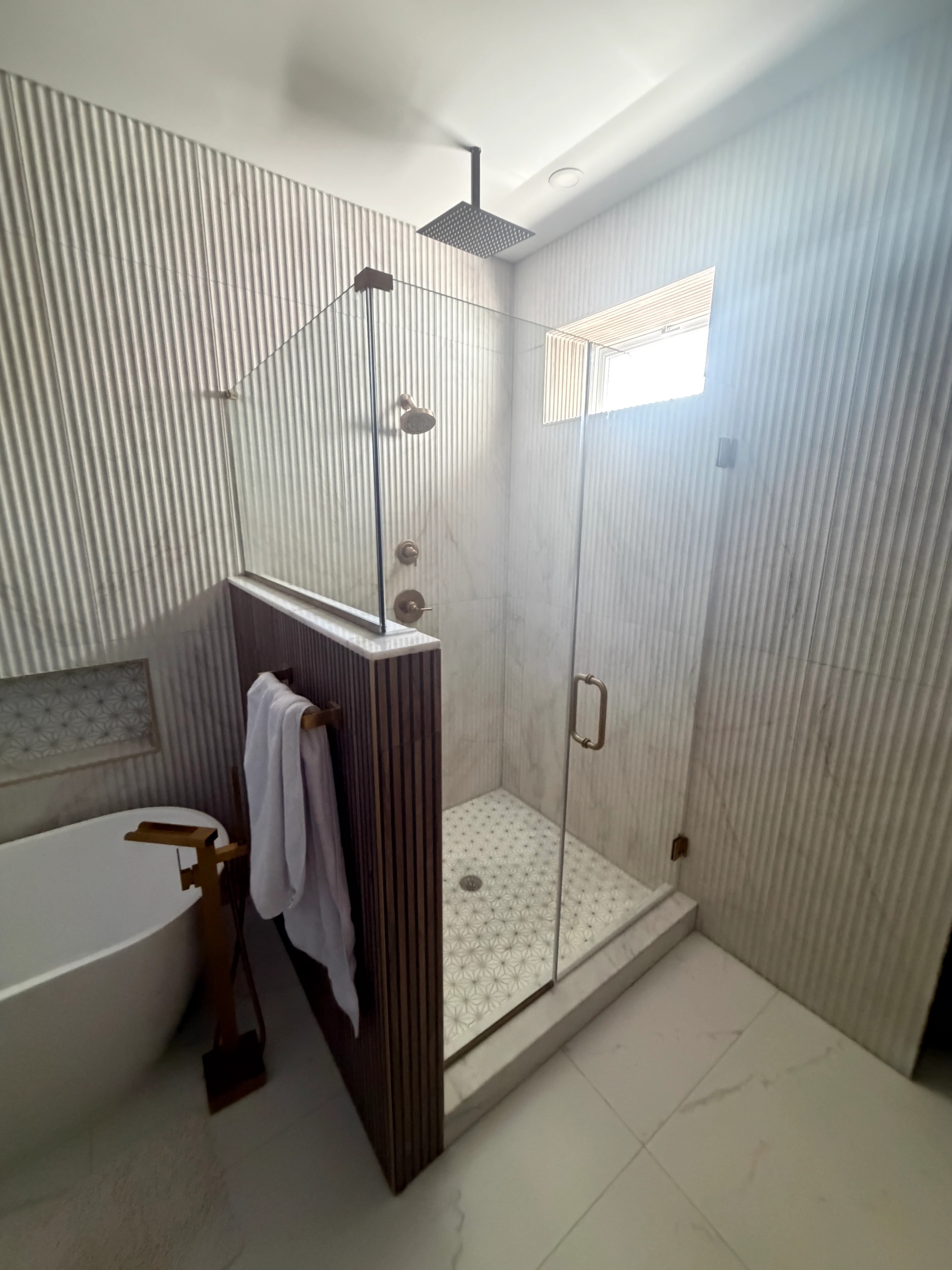 Custom frameless glass shower enclosure professionally installed in modern bathroom