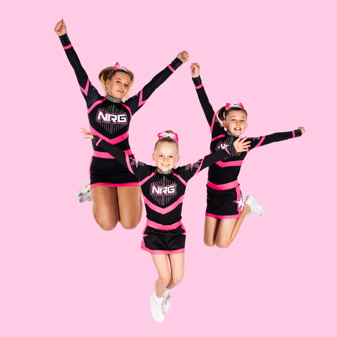 Three Pink Stream recreational cheerleaders from NRG Studios Allstars jumping with joy, showcasing their love for cheerleading classes in Wollongong