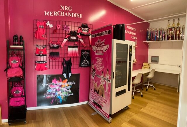 Uniform area at NRG Studios Allstars in Wollongong with pink walls, displaying dance and cheerleading uniforms for students of all ages