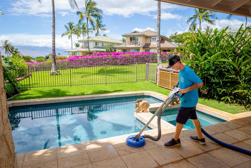 CSI cleaner thoroughly cleaning a poolside patio, showcasing attention to detail and commitment to quality service in a tropical setting