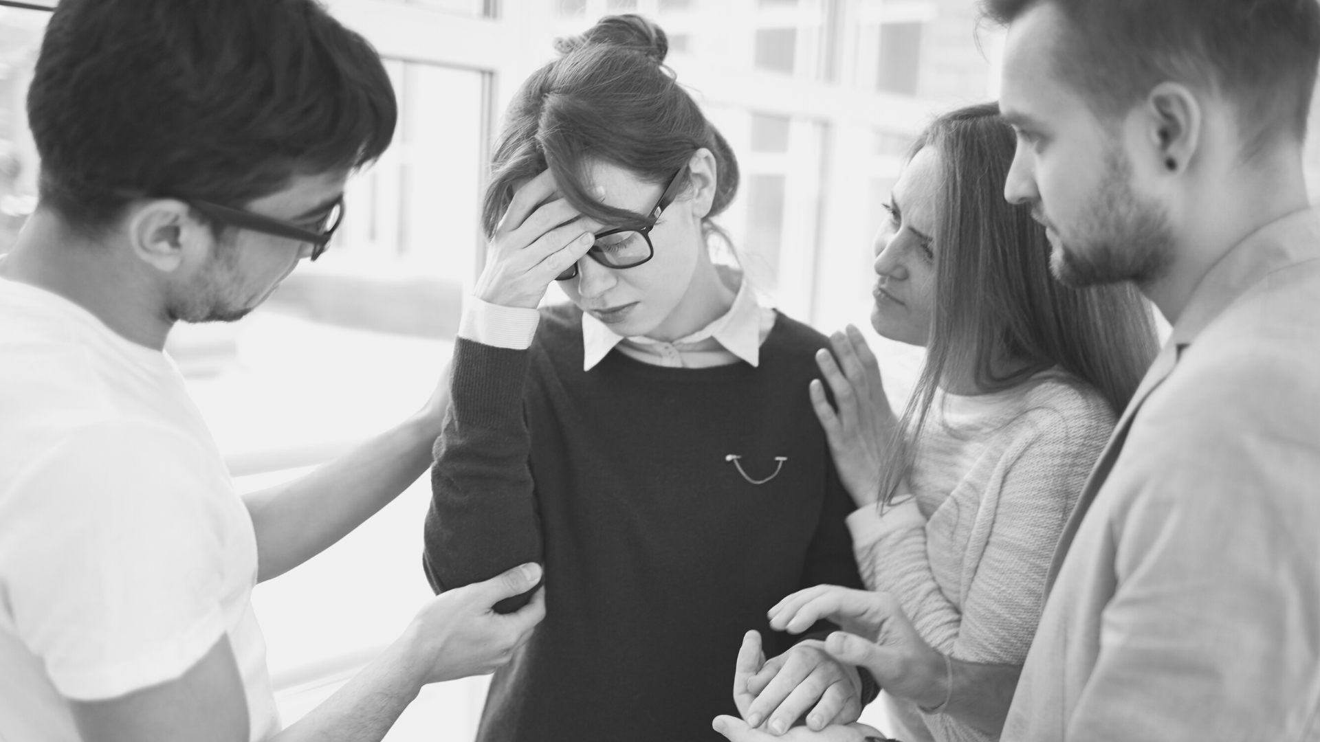 Group of people looking at a phone with concern