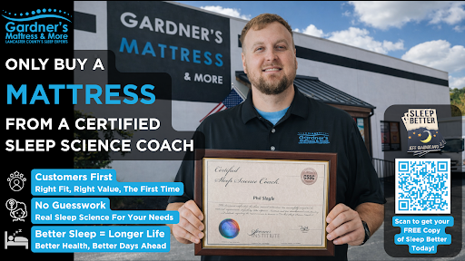 Certified sleep science coach holding diploma outside Gardner’s Mattress & More, advertising expert mattress buying guidance and free sleep consultation via QR code