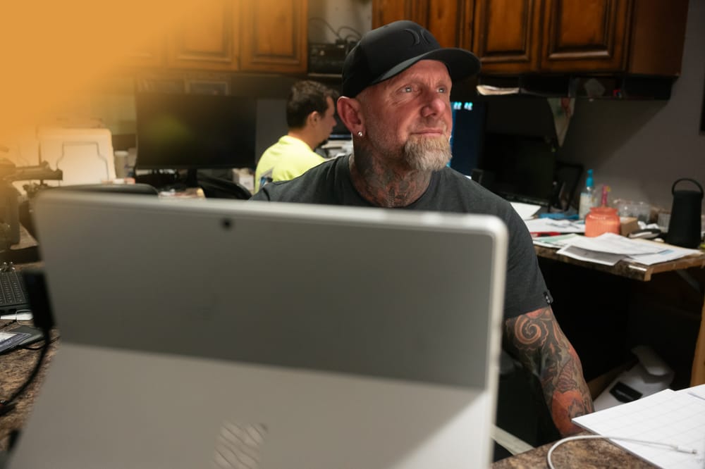 Jason Trester managing business strategy at his office desk — outcome-driven coaching in action