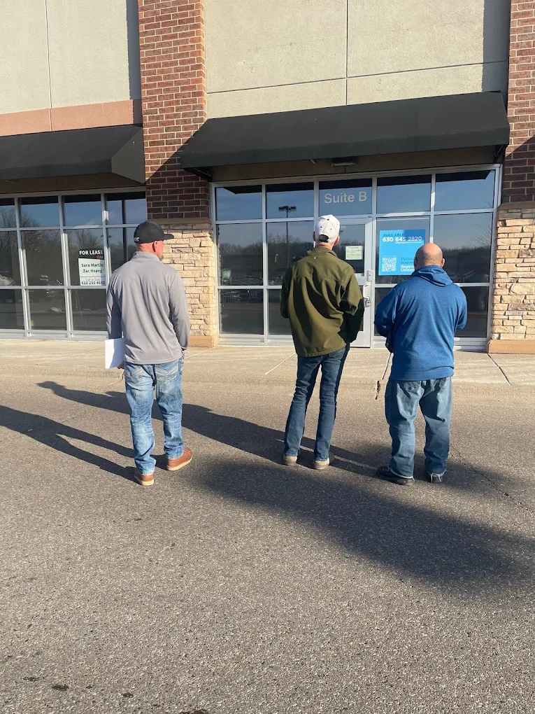 Jason and business owners evaluating a new commercial building site for business expansion