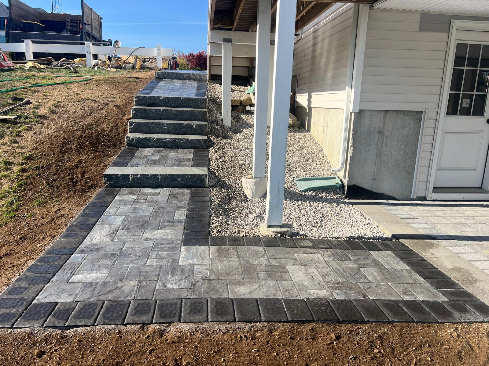 Contemporary fire pit area with circular seating wall, surrounded by manicured lawn and subtle landscape lighting, perfect for evening gatherings.