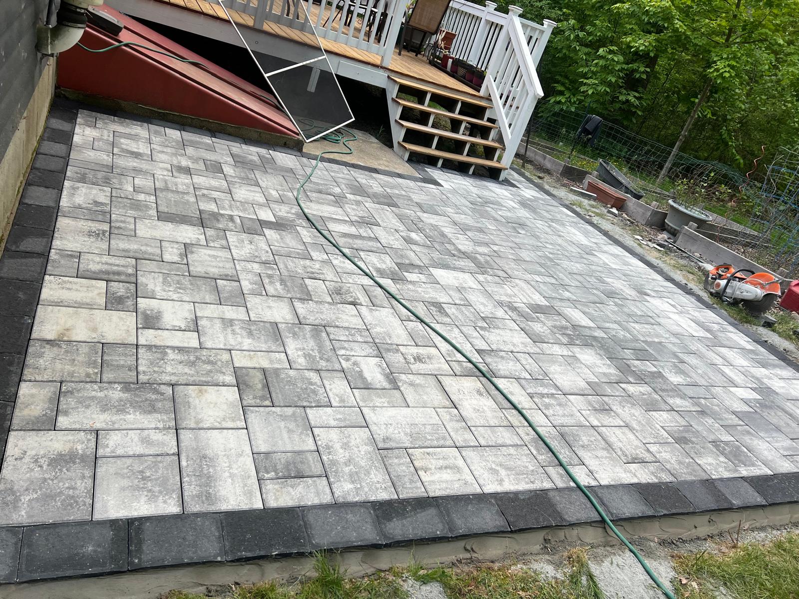 Elegant stone walkway winding through a lush garden with blooming flowers and mature trees, designed for a tranquil residential setting.