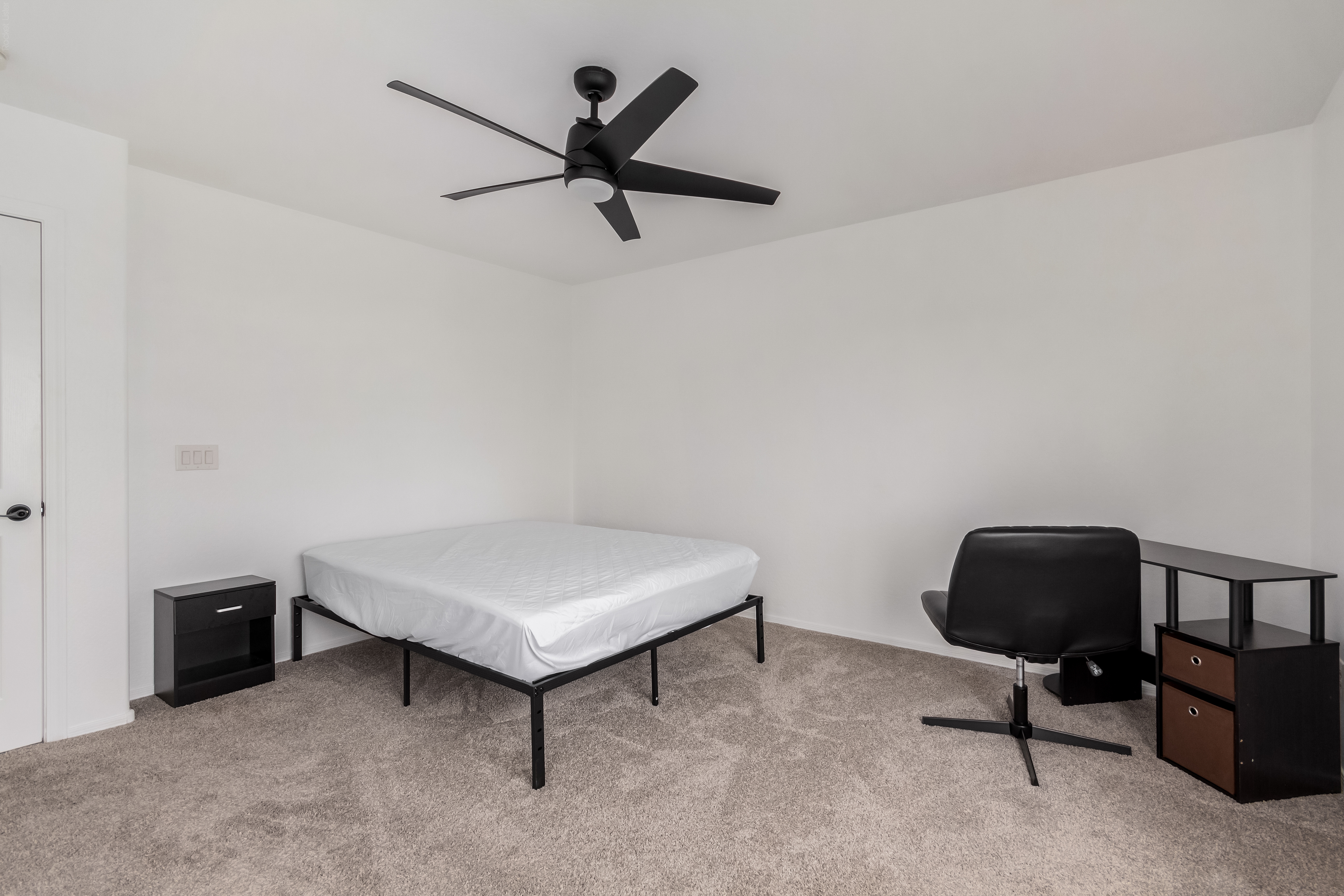 Downstairs primary bedroom suite with sitting area at 18663 W Vogel Ave Goodyear AZ