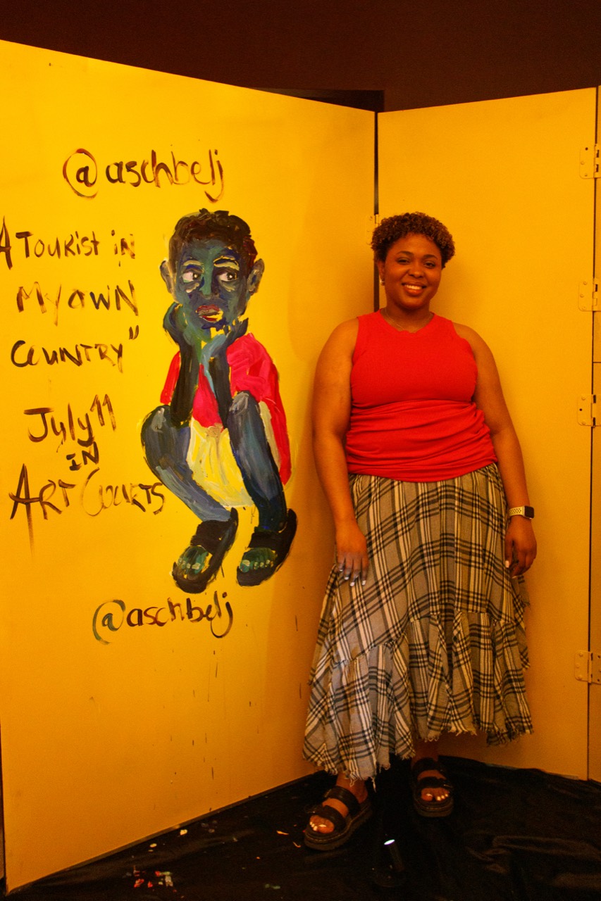 Kouka standing beside her artwork