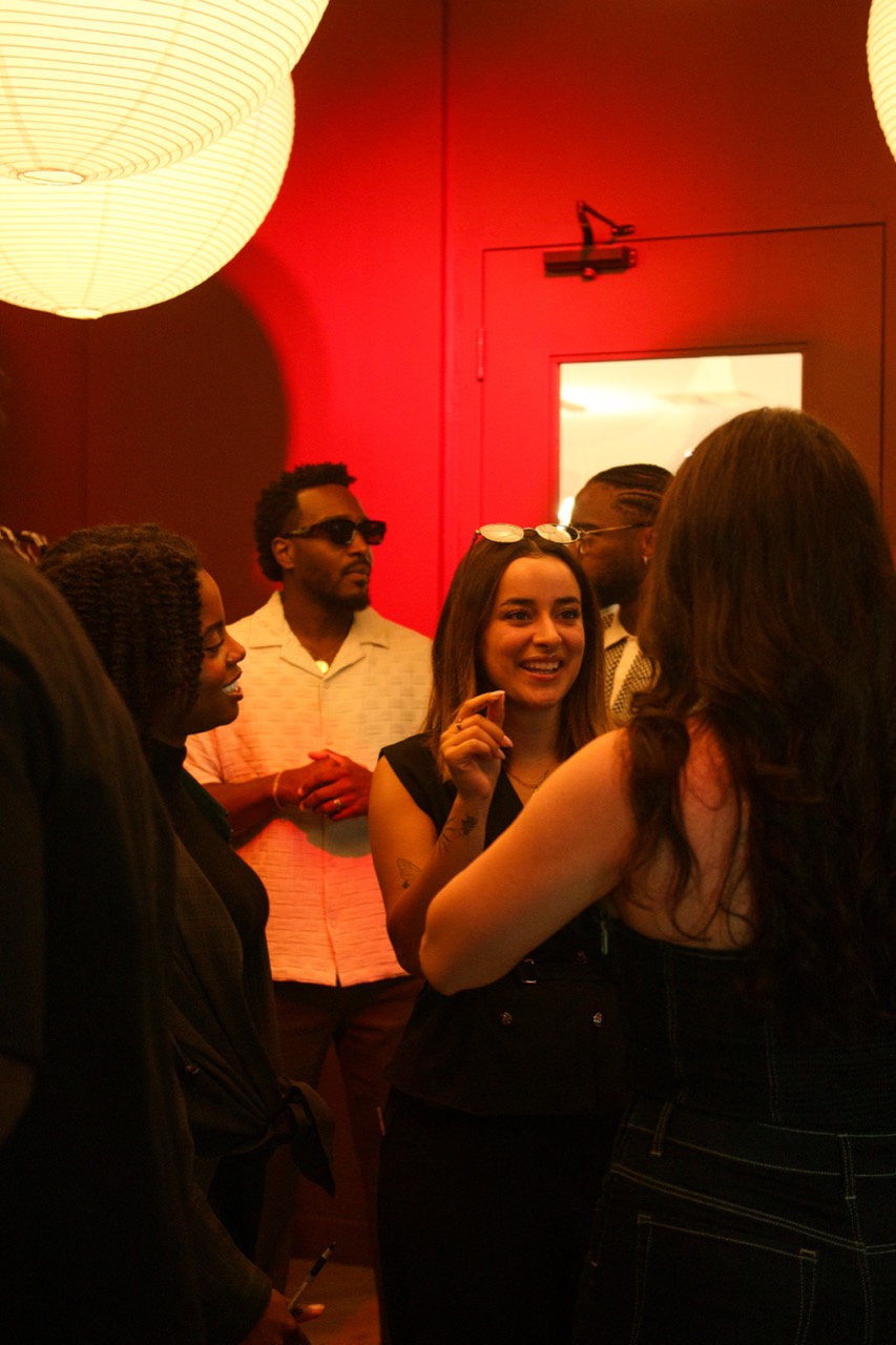 Guests connecting beneath the red room lighting
