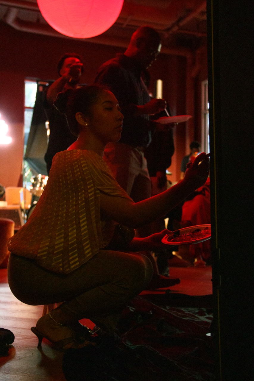 A guest painting under the red event lighting