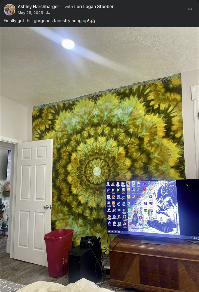 Large green, gold, aqua, and black tie-dyed mandala tapestry displayed on a bedroom wall