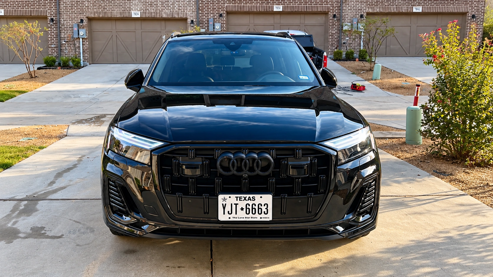 Glossy black vehicle exterior reflecting light after a mobile detailing service