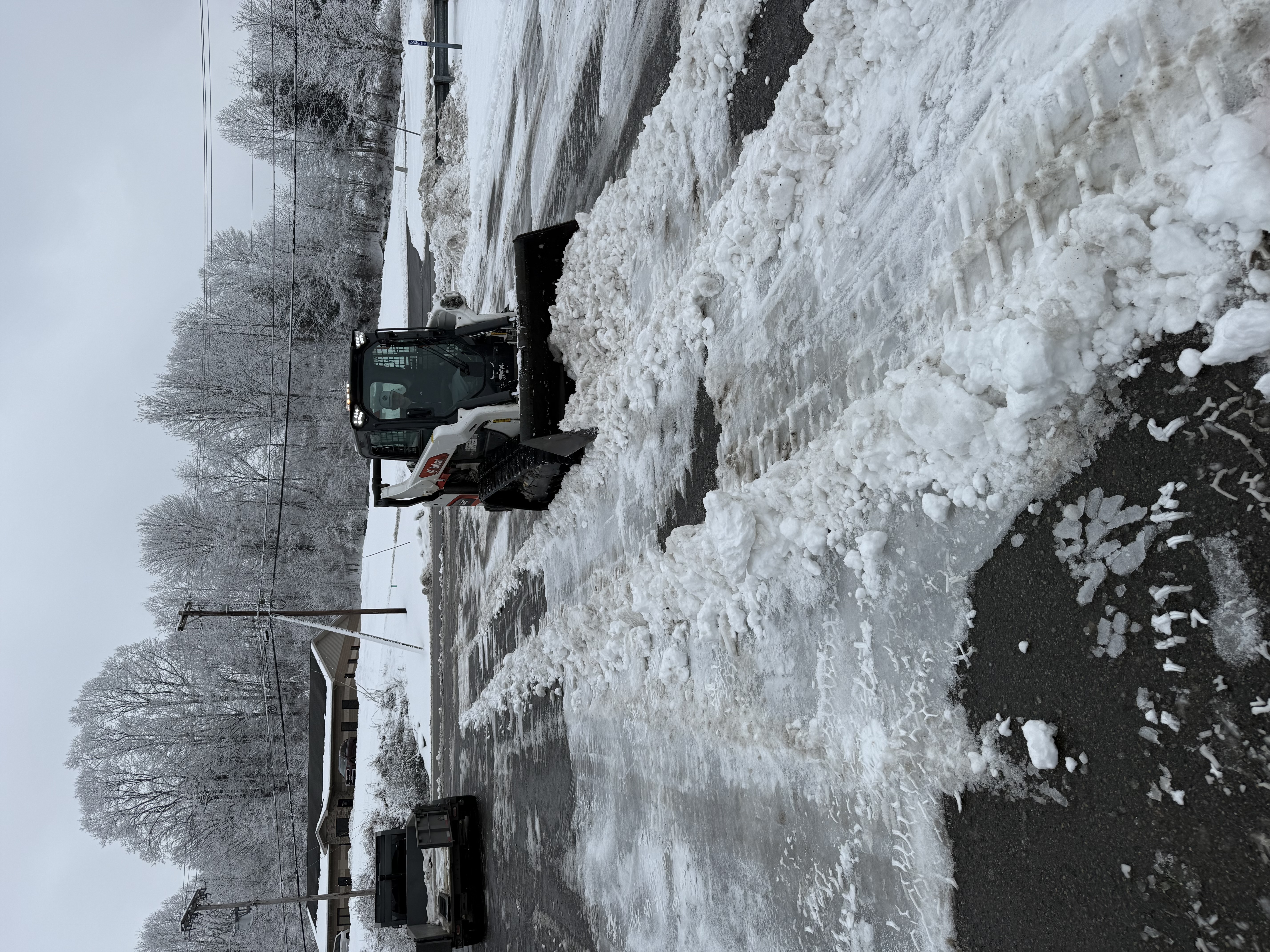Snow removal clearing a driveway and property during winter storm