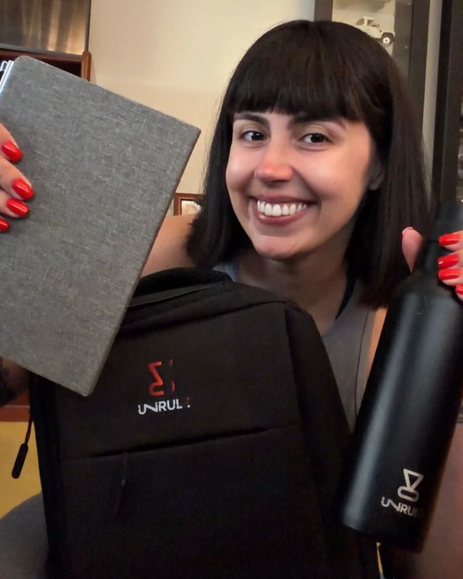 Ana Brandão a sorrir com o caderno, a mochila e a garrafa da UNRULE