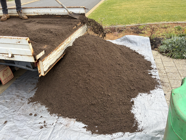 Top dressing being spread on a lawn by Cotton's Mowing