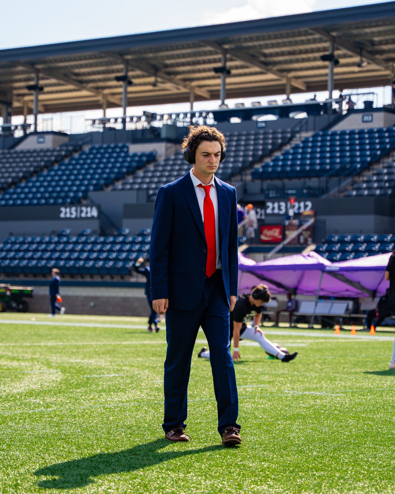 Ty Ippolito walking the field in a suit before a Samford University football game