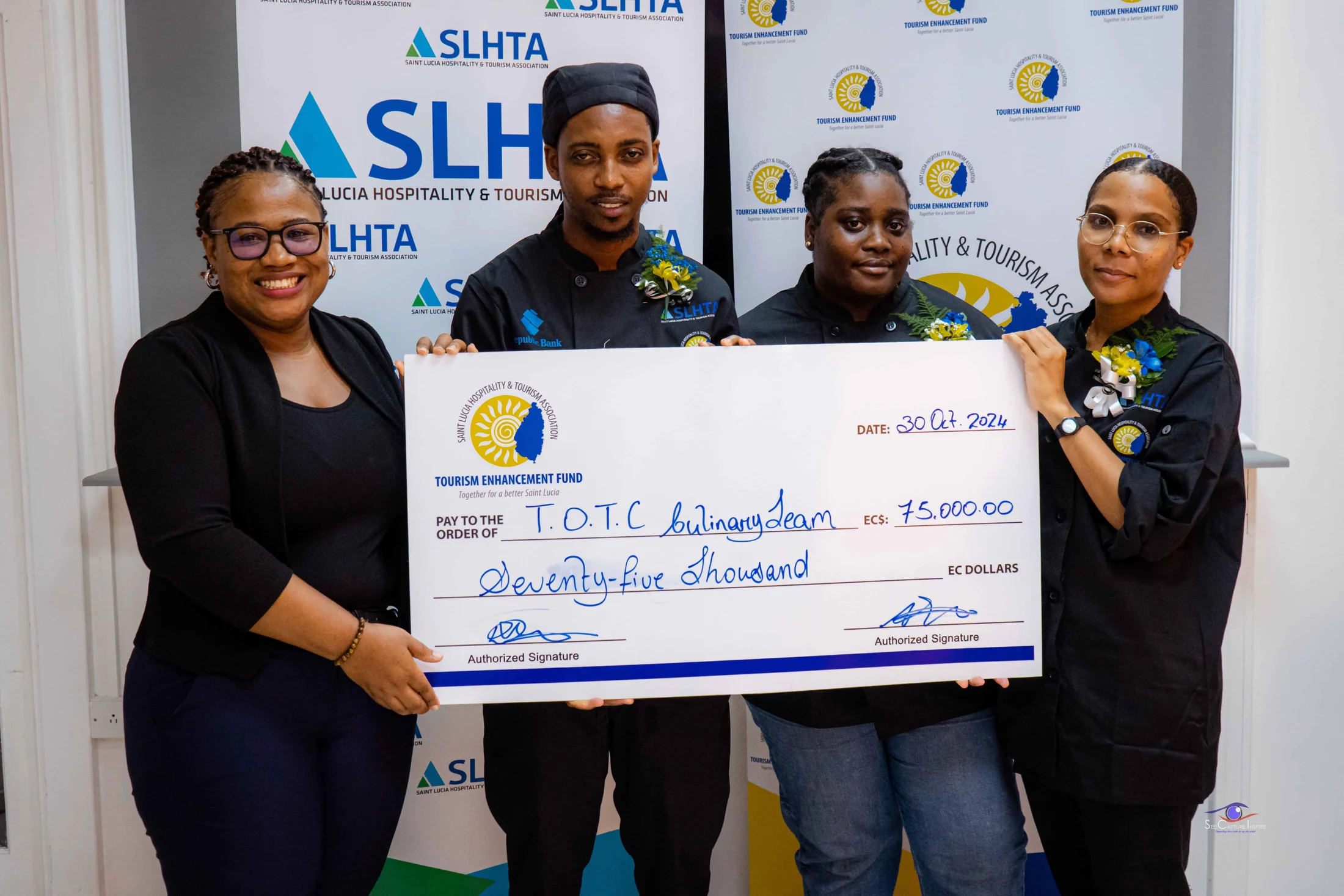 TEF presents a cheque for EC$75,000 to the T.O.T.C. culinary team, two chefs in whites