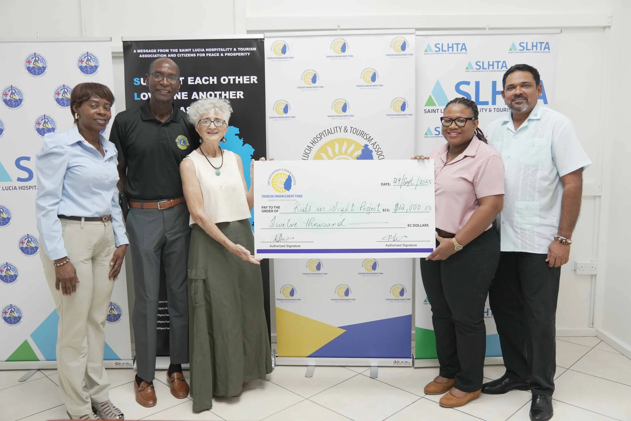 Five people hold a TEF presentation cheque in front of SLHTA banners