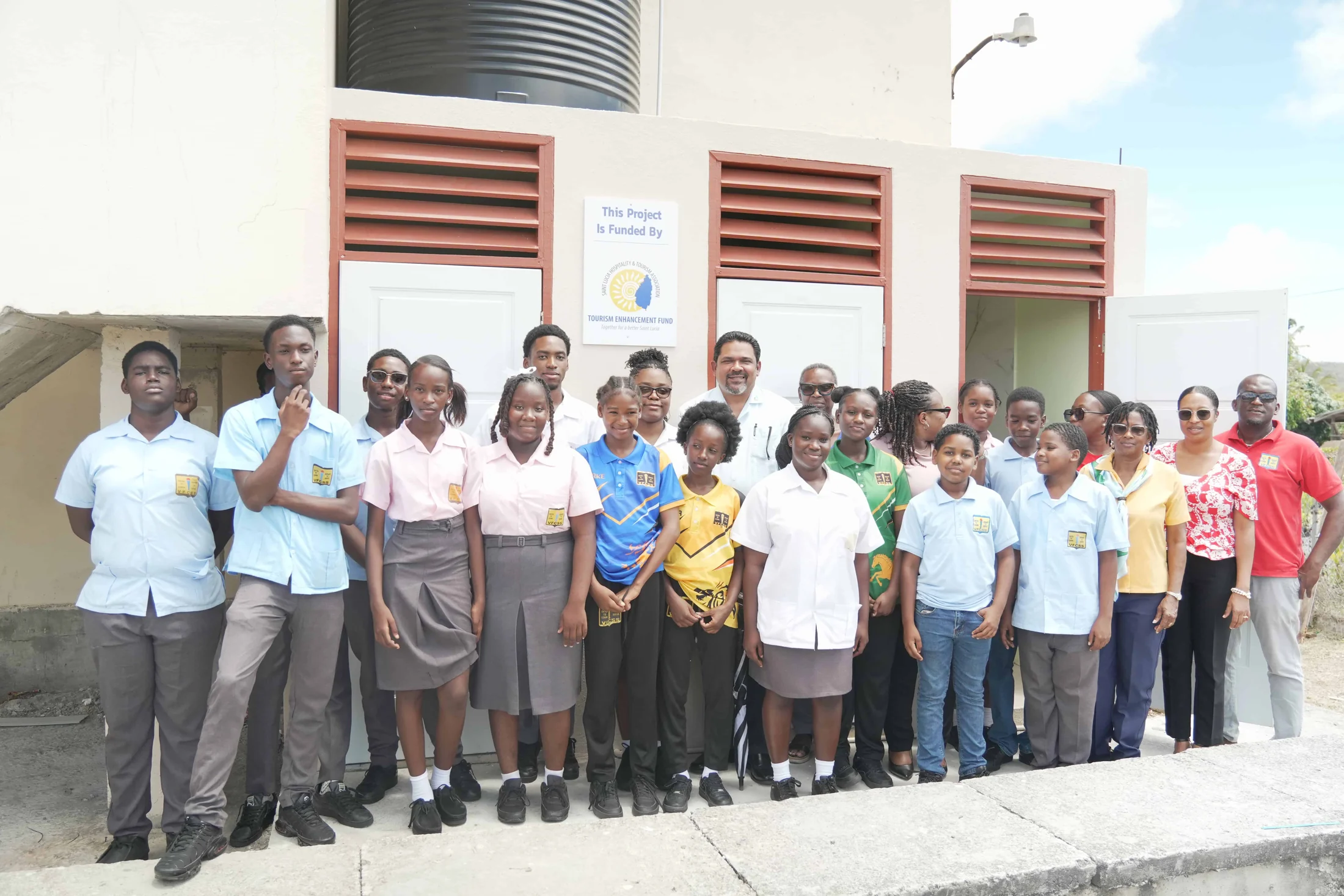 Students outside the refurbished washroom block with the TEF plaque