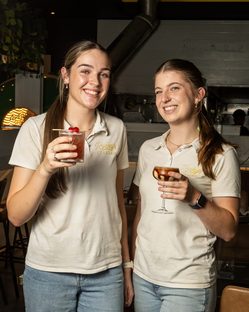 Two Rocky's Italian team members raising cocktails at the bar