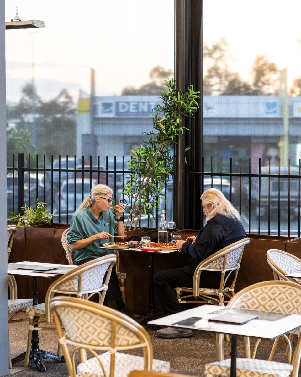 Diners sharing a meal at an outdoor table at Rocky's Italian