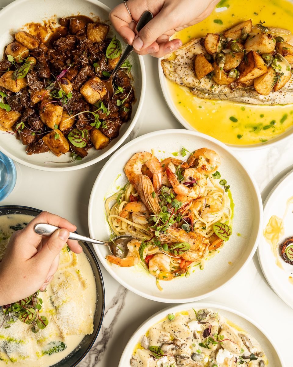 Overhead of a shared table: beef cheek gnocchi, prawn linguine, barramundi and ravioli