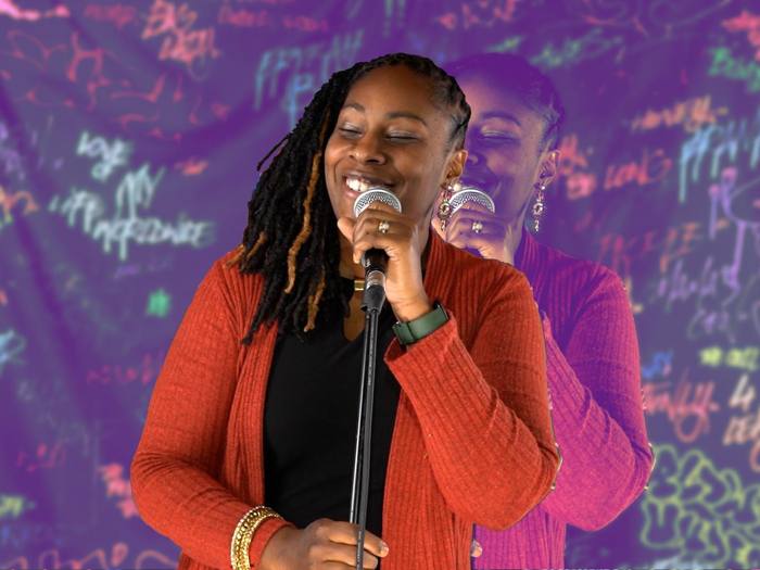 Jori O'Neale performing clean comedy with a microphone
