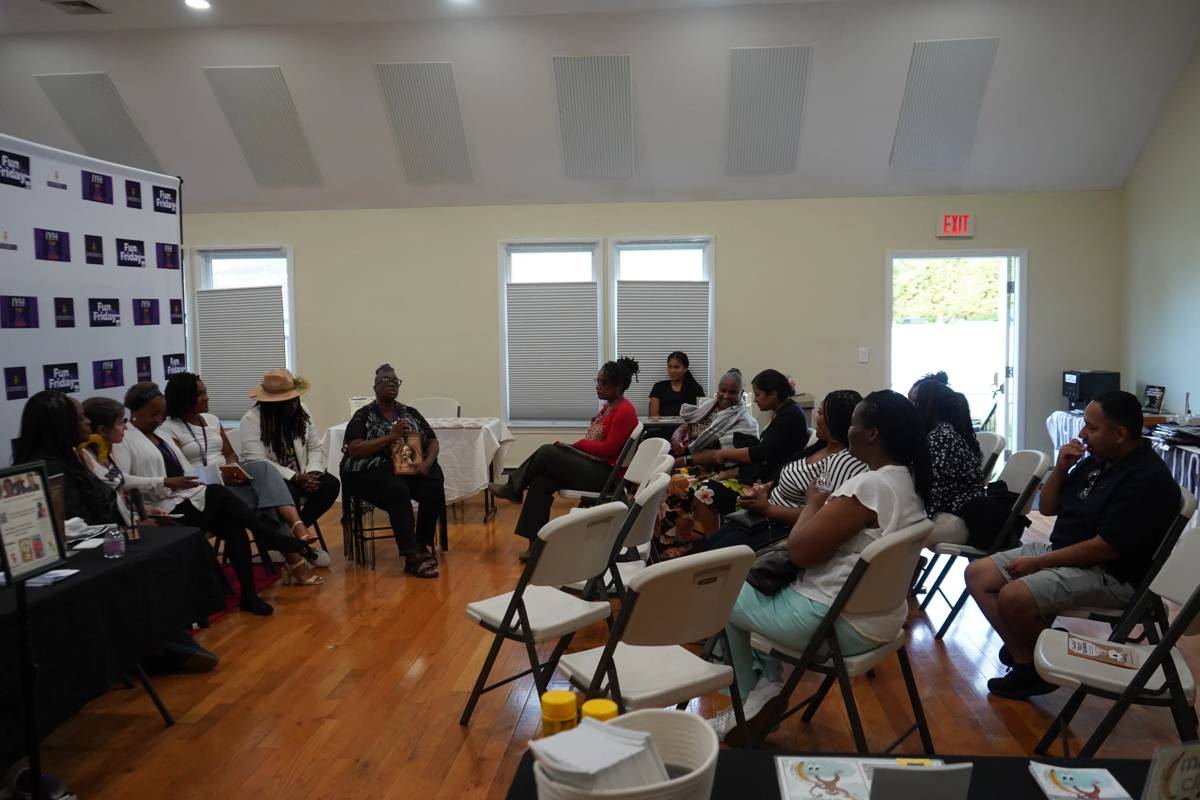 Community members seated in a circle listening to an author discussion at an IYH event