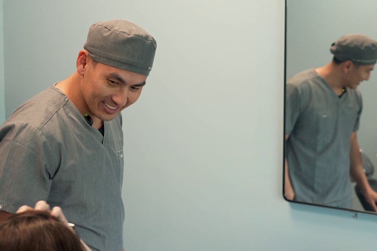 An Elite dentist smiling with a patient in the treatment room