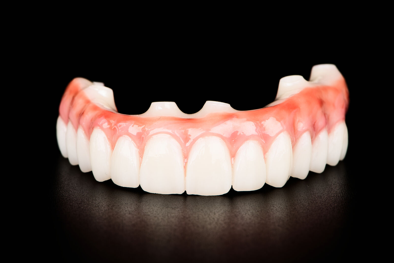 Front view of a zirconia full-arch prosthesis with natural-looking gum shading