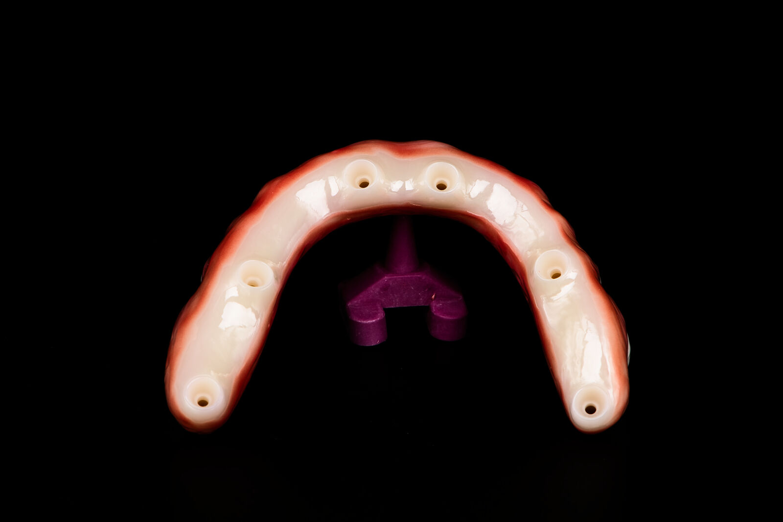 The underside of an Elite zirconia arch showing the implant connection points