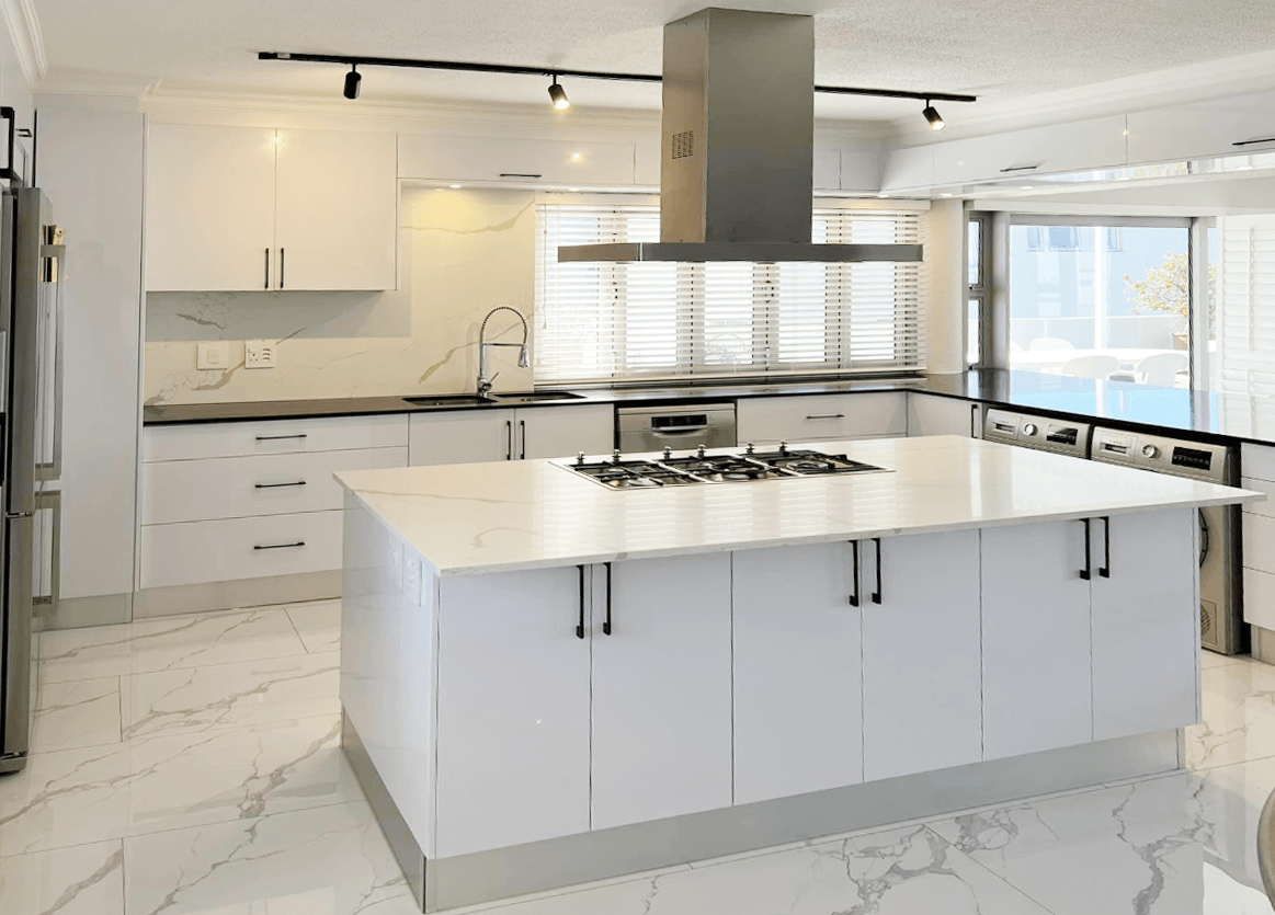 Modern white kitchen with sleek cabinetry and a central island, perfect for custom kitchens in Plettenberg Bay.