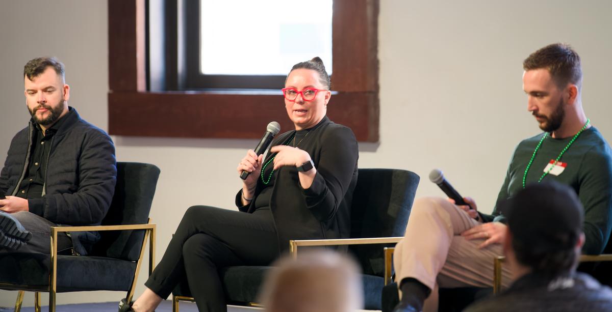 A fireside chat with three speakers seated on stage