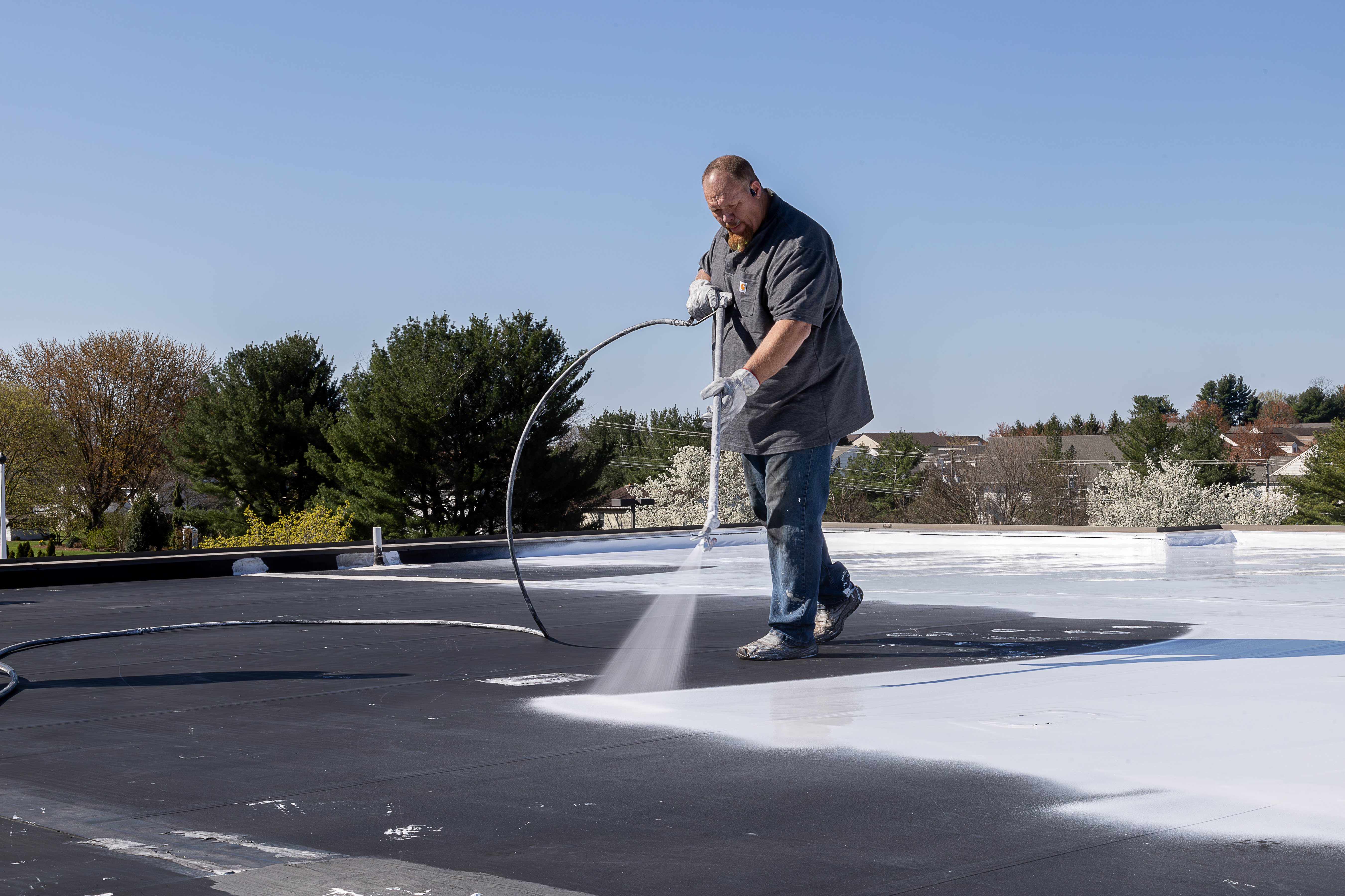 Tim Schultz from Schultz Roofing applying a commercial roof coating.