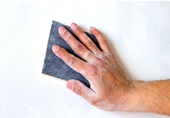 Sanding and prepping a wall surface before painting