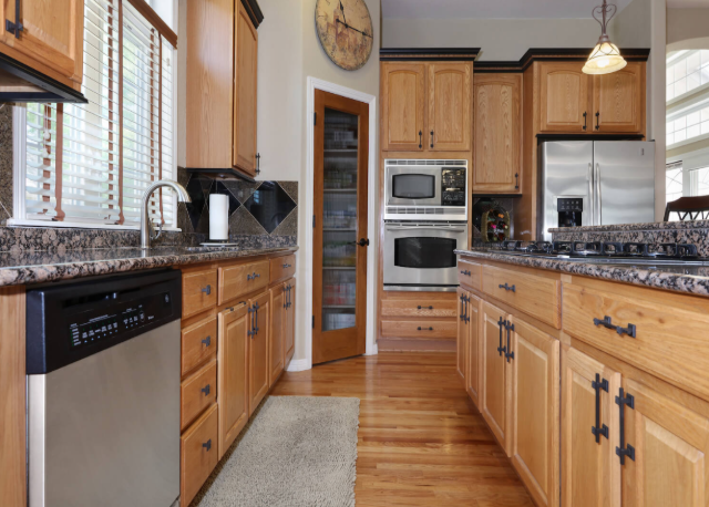 Refinished wood kitchen cabinets with updated hardware