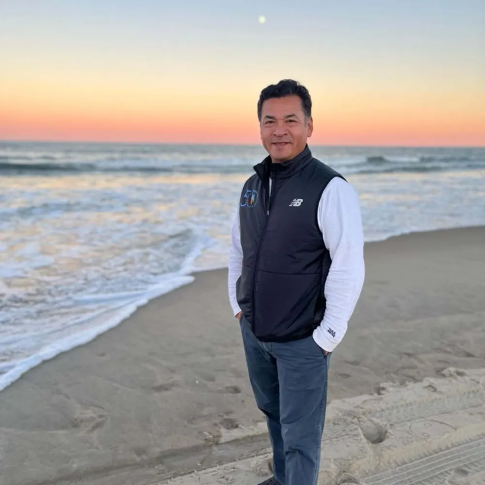 Jose, founder of Vantaire, standing on an Outer Banks beach at sunset