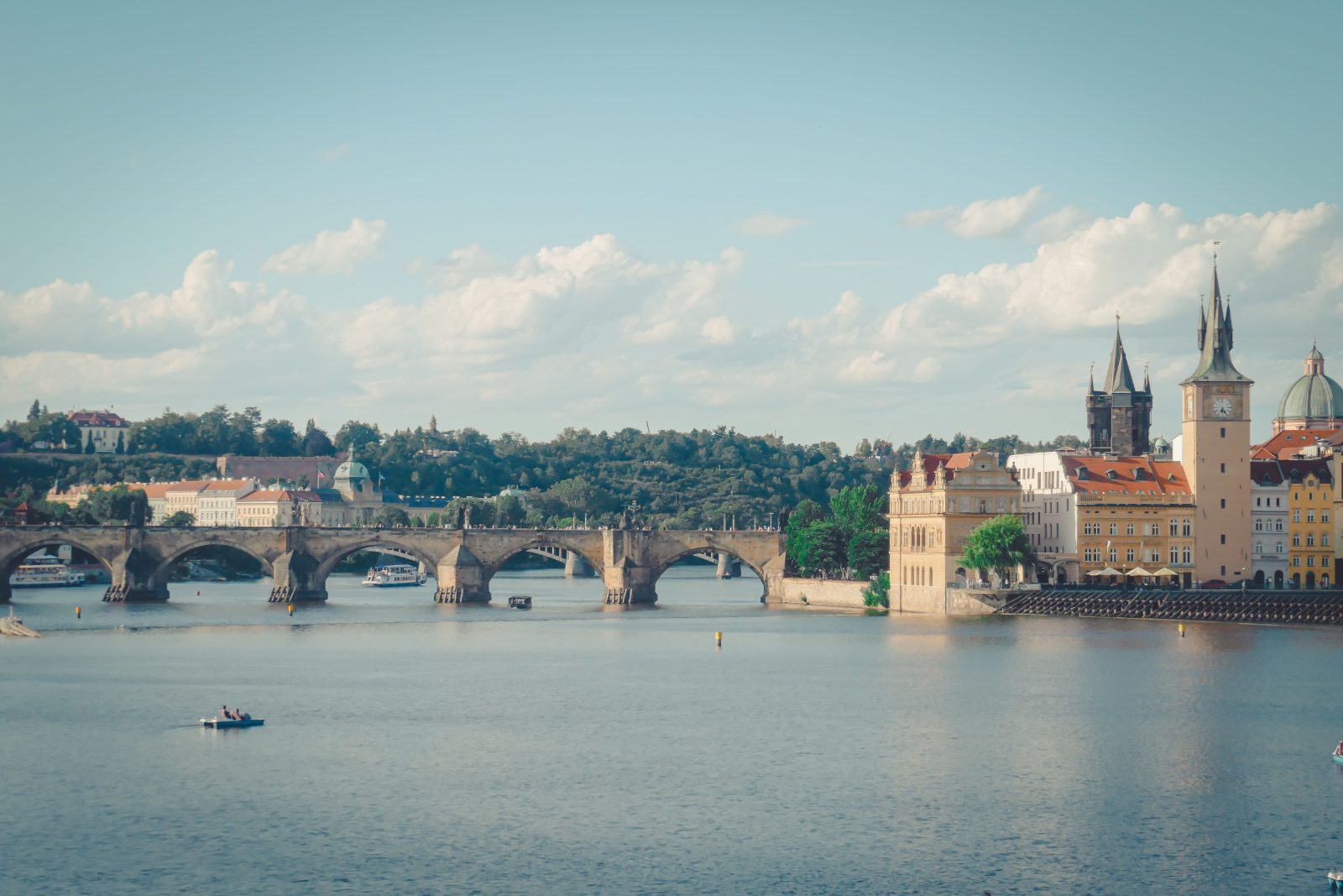 Scenic daytime view of Charles Bridge and the Vltava river in Prague with riverside buildings