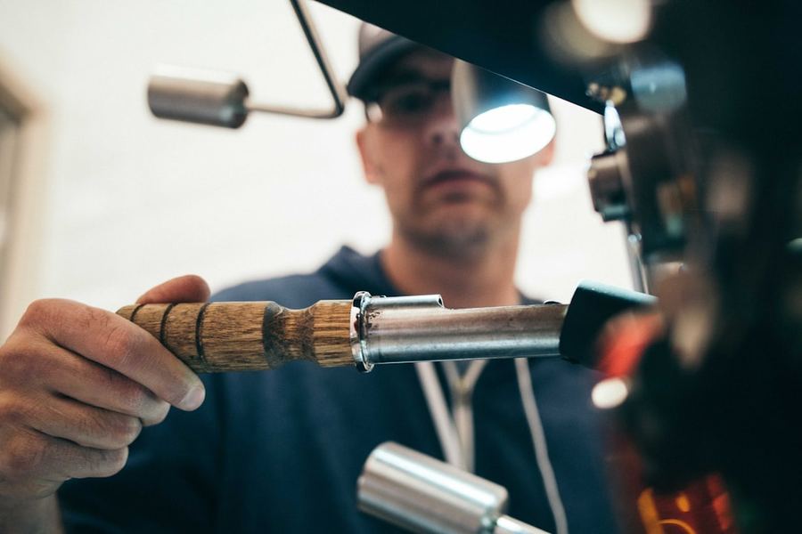 Licensed plumber in Uganda inspecting a copper pipe joint with a headlamp — professional plumbing services Kampala, WebFast24 plumber website design