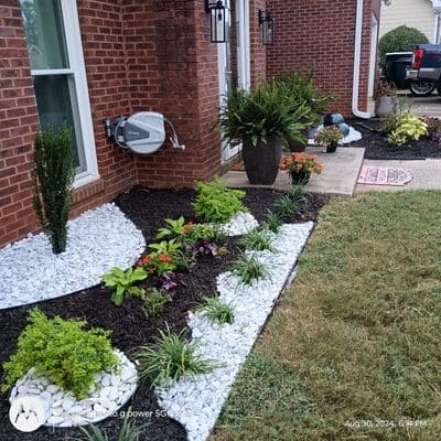 Modern front yard landscaping with decorative white rocks and plants