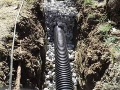 Gravel and pipe trench installation for water drainage control