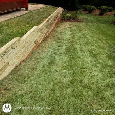 Stone retaining wall for soil stabilization in a sloped backyard