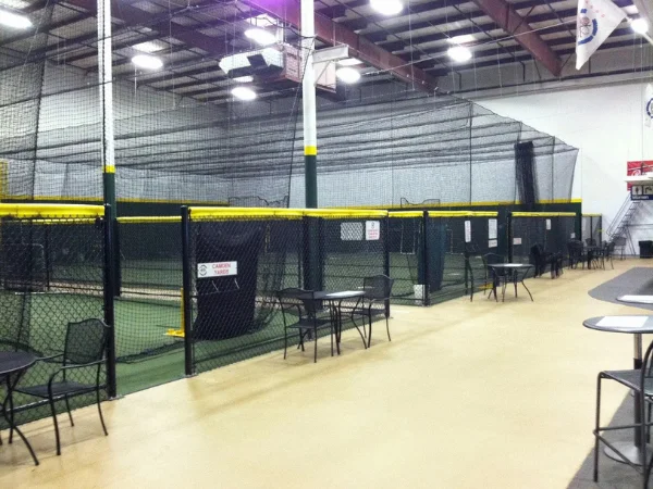 Indoor baseball hitting program training area with batting cages and practice stations