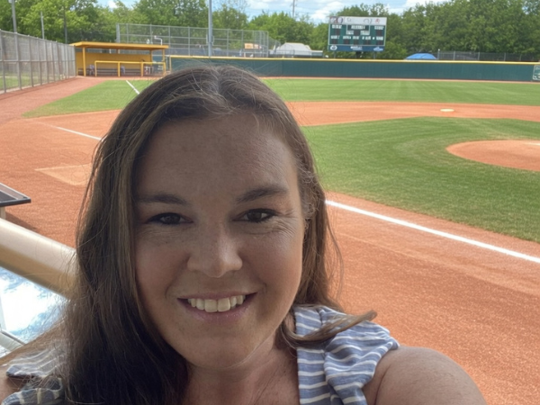  Smiling instructor taking a selfie near a baseball field