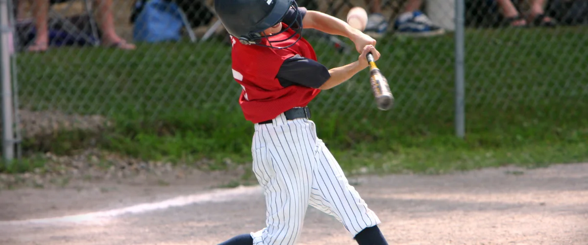 A young boy in a red jersey and pinstripe pants swinging a baseball bat with motion blur. A young boy in a red jersey and pinstripe pants swinging a baseball bat with motion blur.