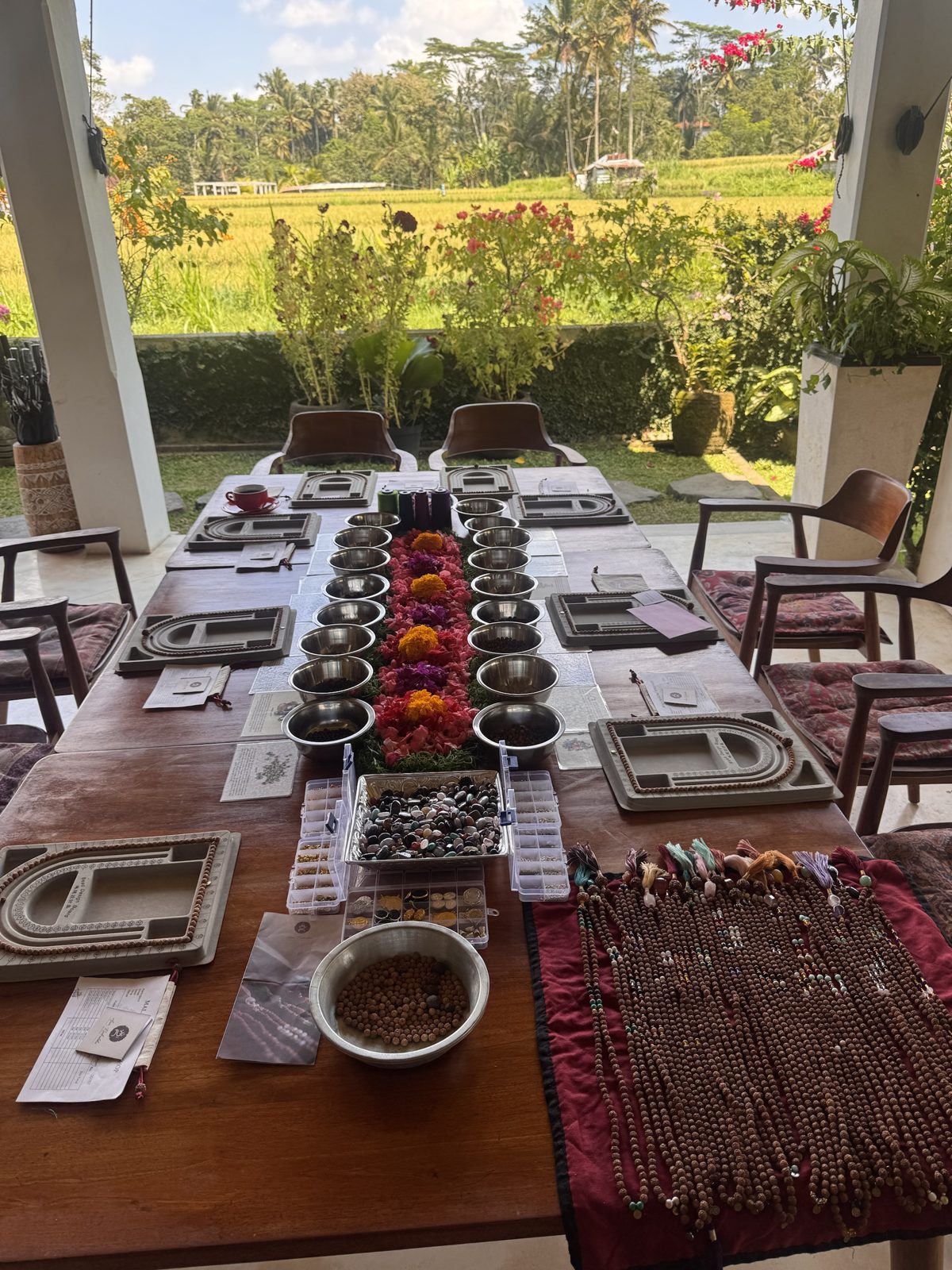Mala bead making table set with flowers, overlooking the rice fields in Ubud
